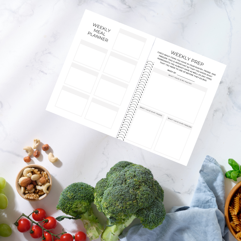 Flat lay of Weekly Meal Planner and Weekly Prep spread with fresh produce and assorted nut mix.