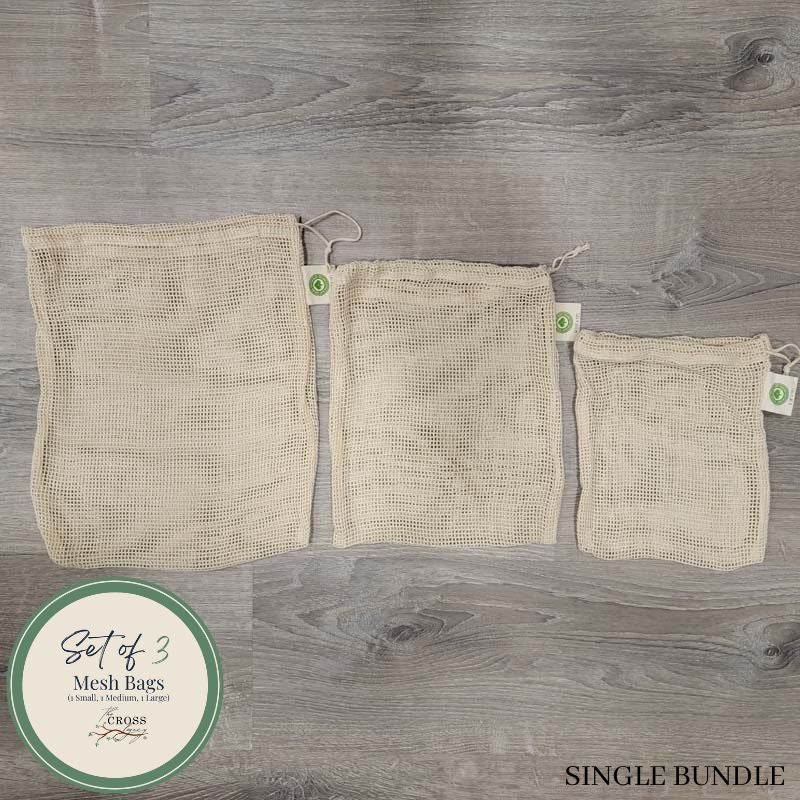 small, medium, and large mesh produce bags lined up in a row on a wood surface
