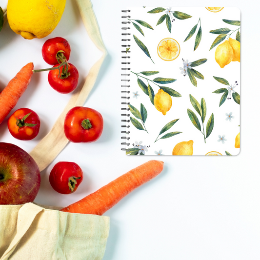 Lemon Floral spiral bound Grocery Planner flay lay with canvas bag filled with fresh produce spilling out of it.