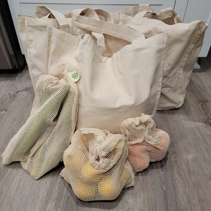 organic shopping bags and mesh produce bags filled with produce in the kitchen